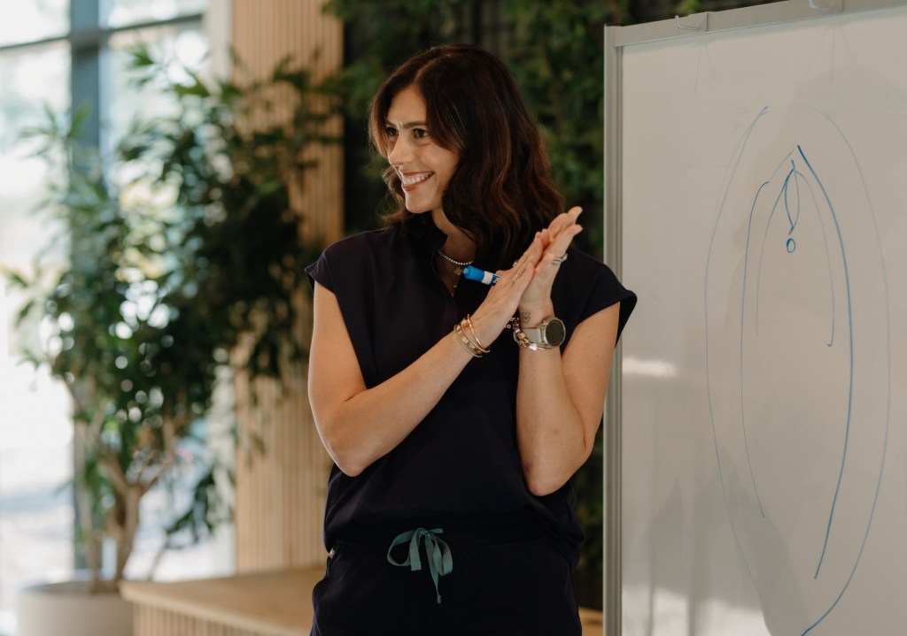 Courtney DuBois Shihabuddin teaching at a whiteboard during a clinical education session